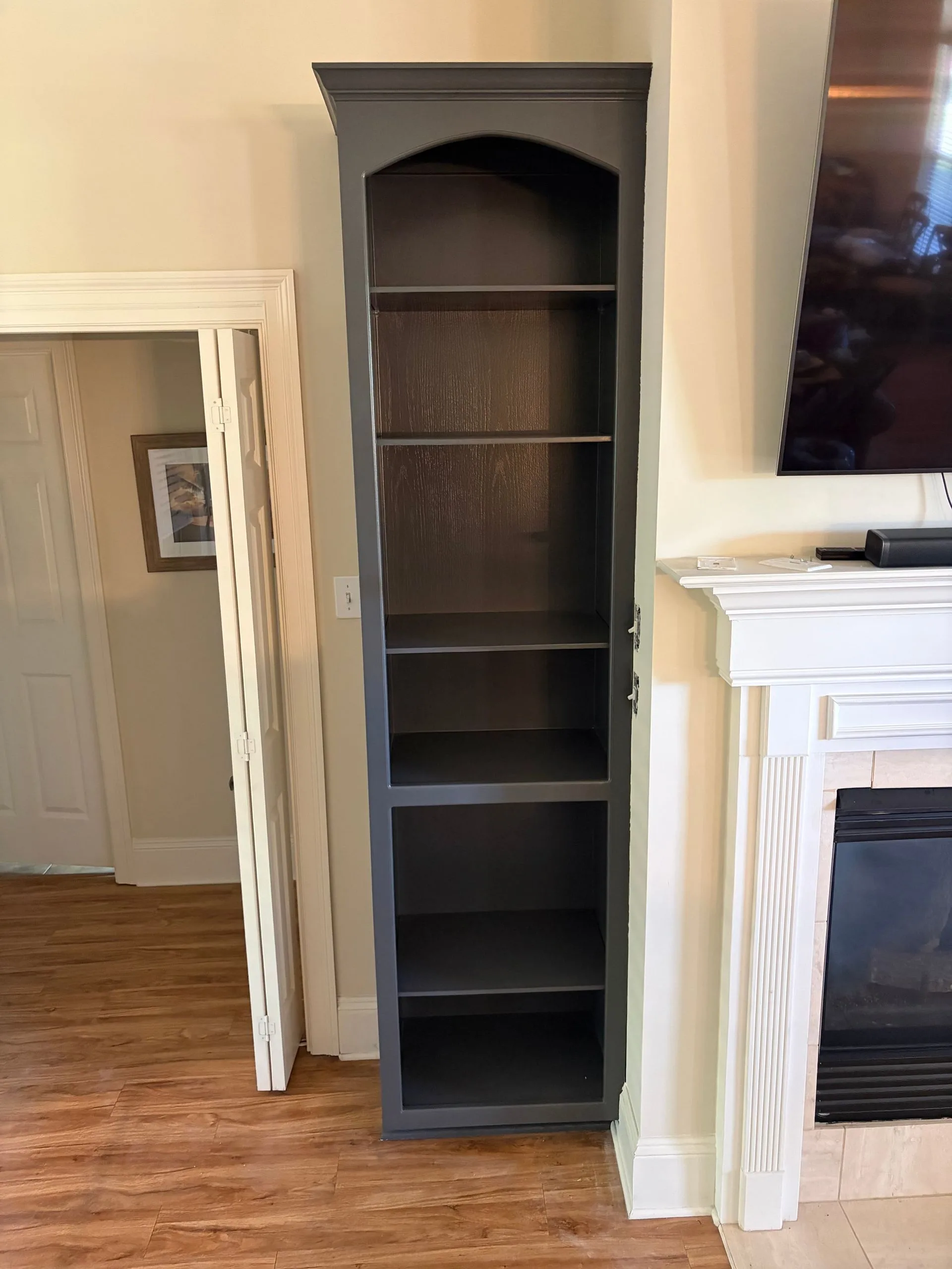 Bookcase beside a fireplace repainted dark charcoal by 3H Construction
