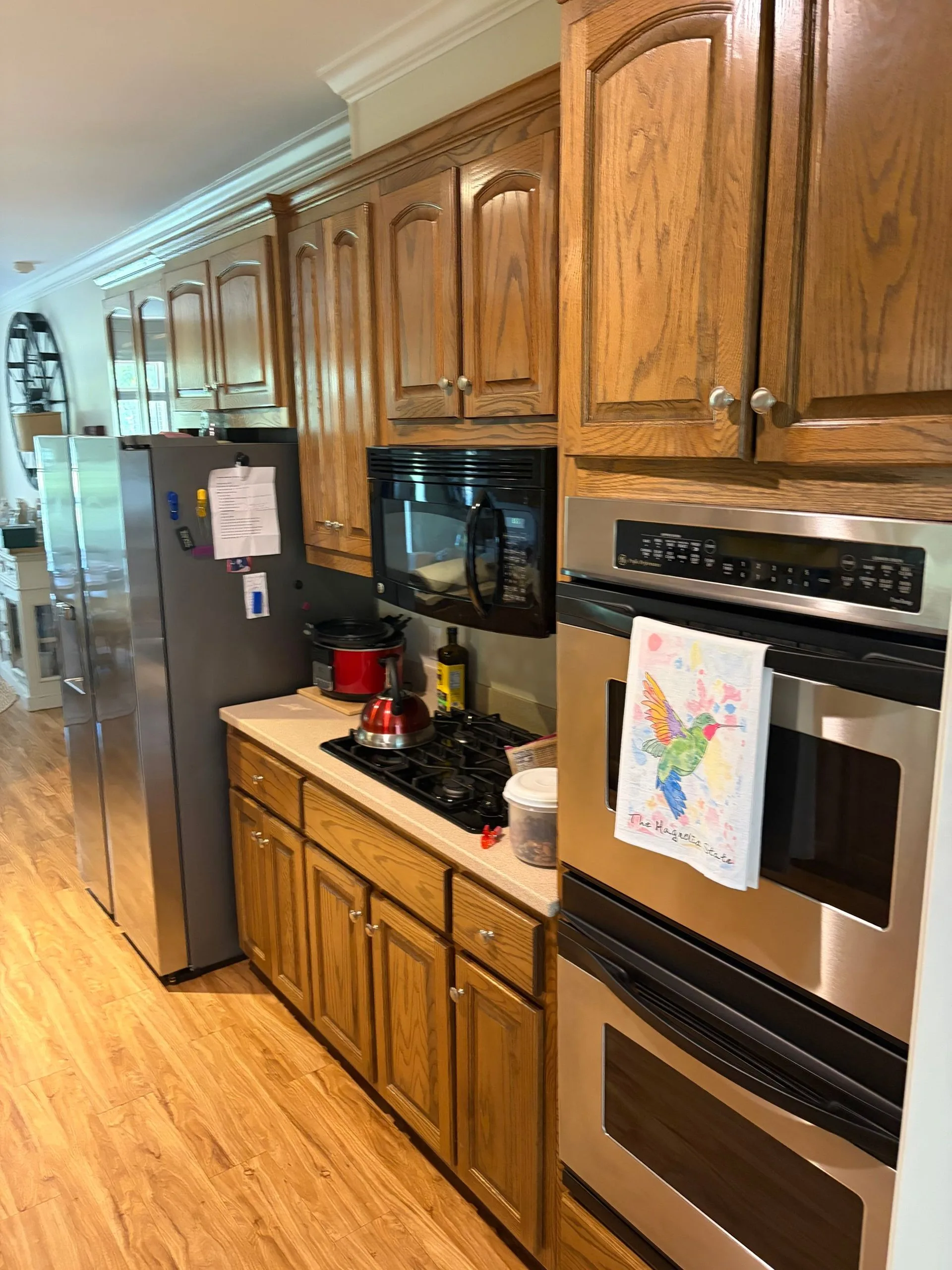 Natural oak kitchen with stainless double oven before repainting by 3H Construction