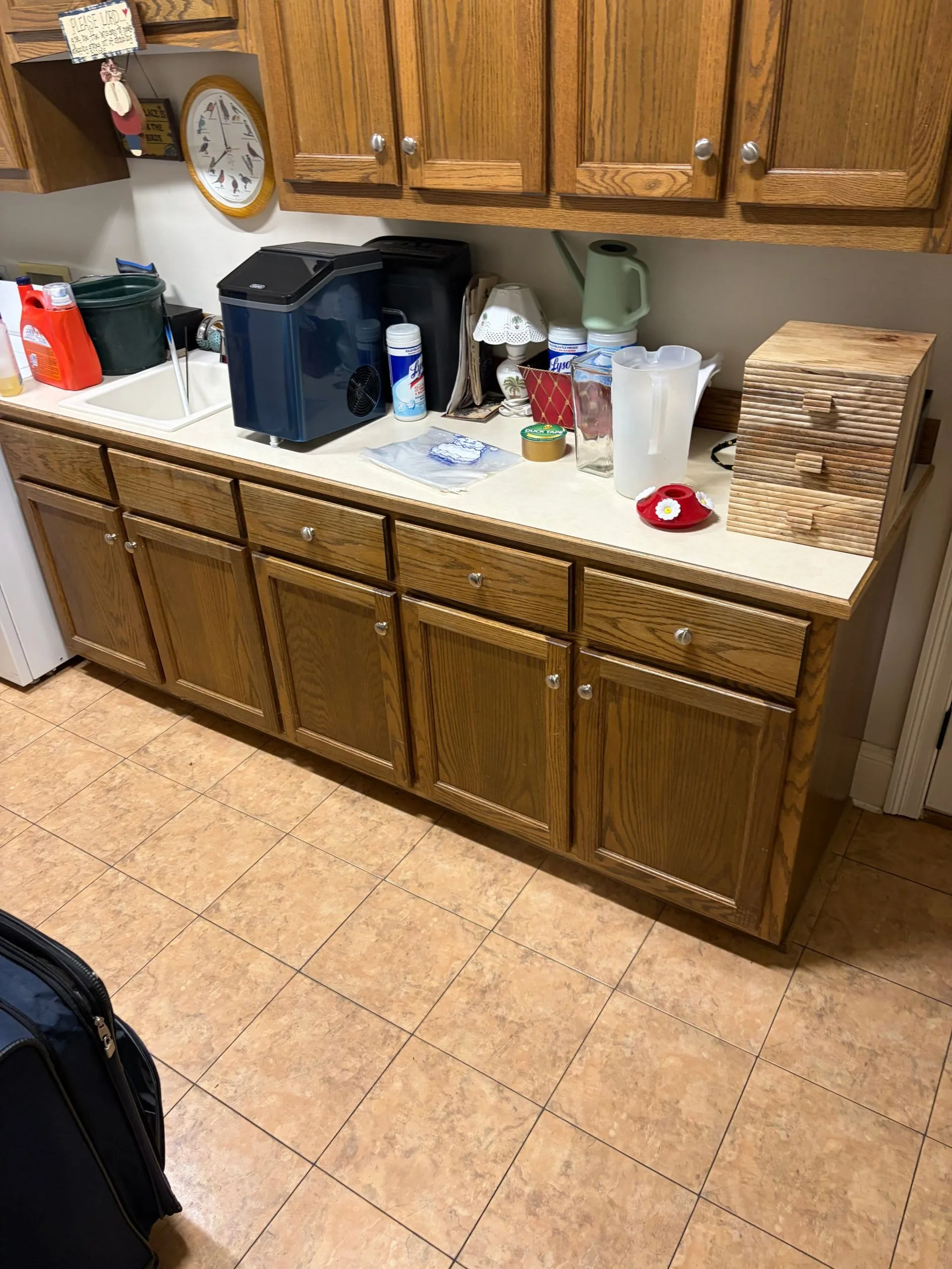 Natural oak laundry room cabinets before repainting by 3H Construction