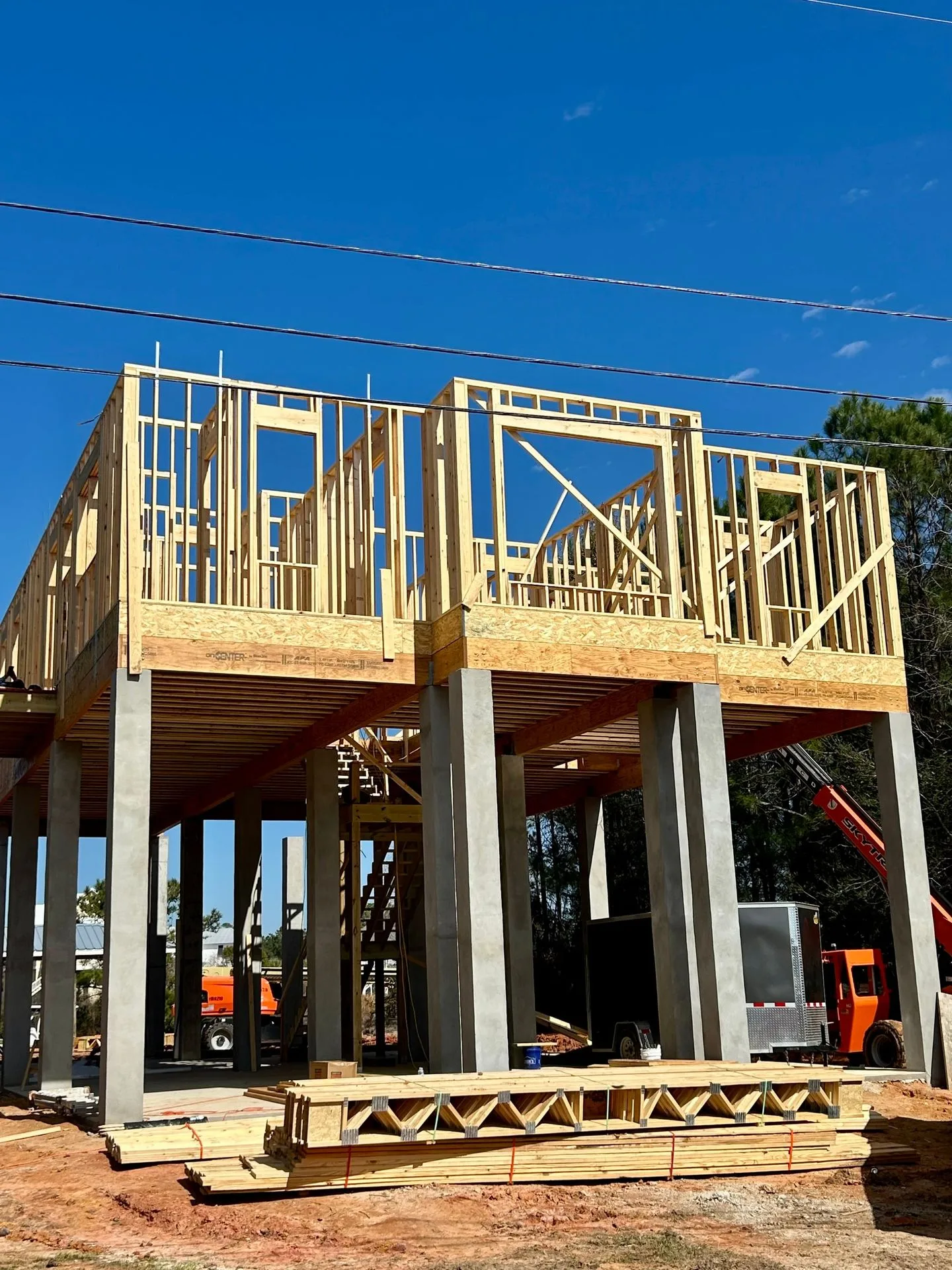 Wood wall framing on pilings for an elevated custom home by 3H Construction