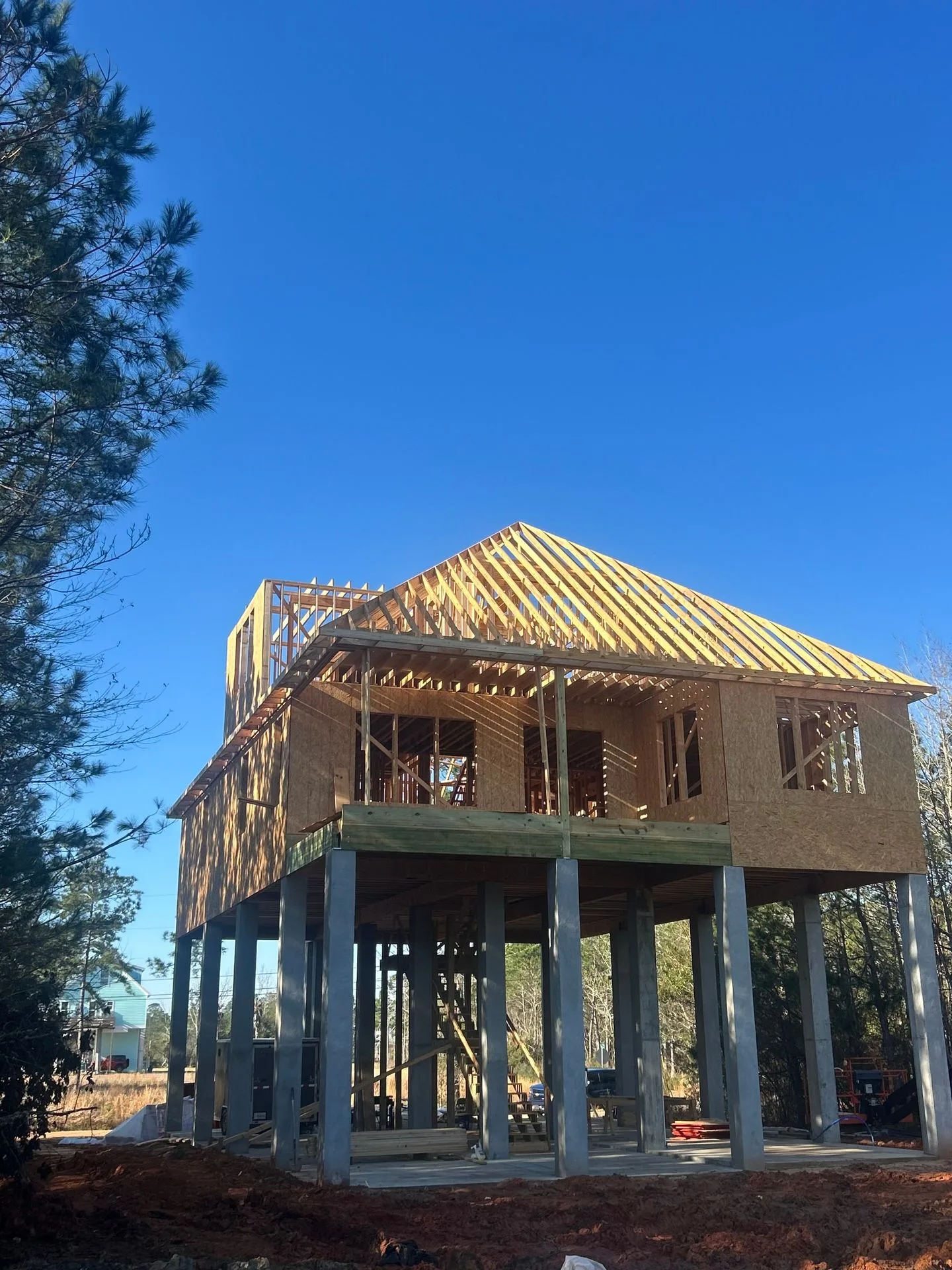 Roof truss framing on an elevated custom home by 3H Construction
