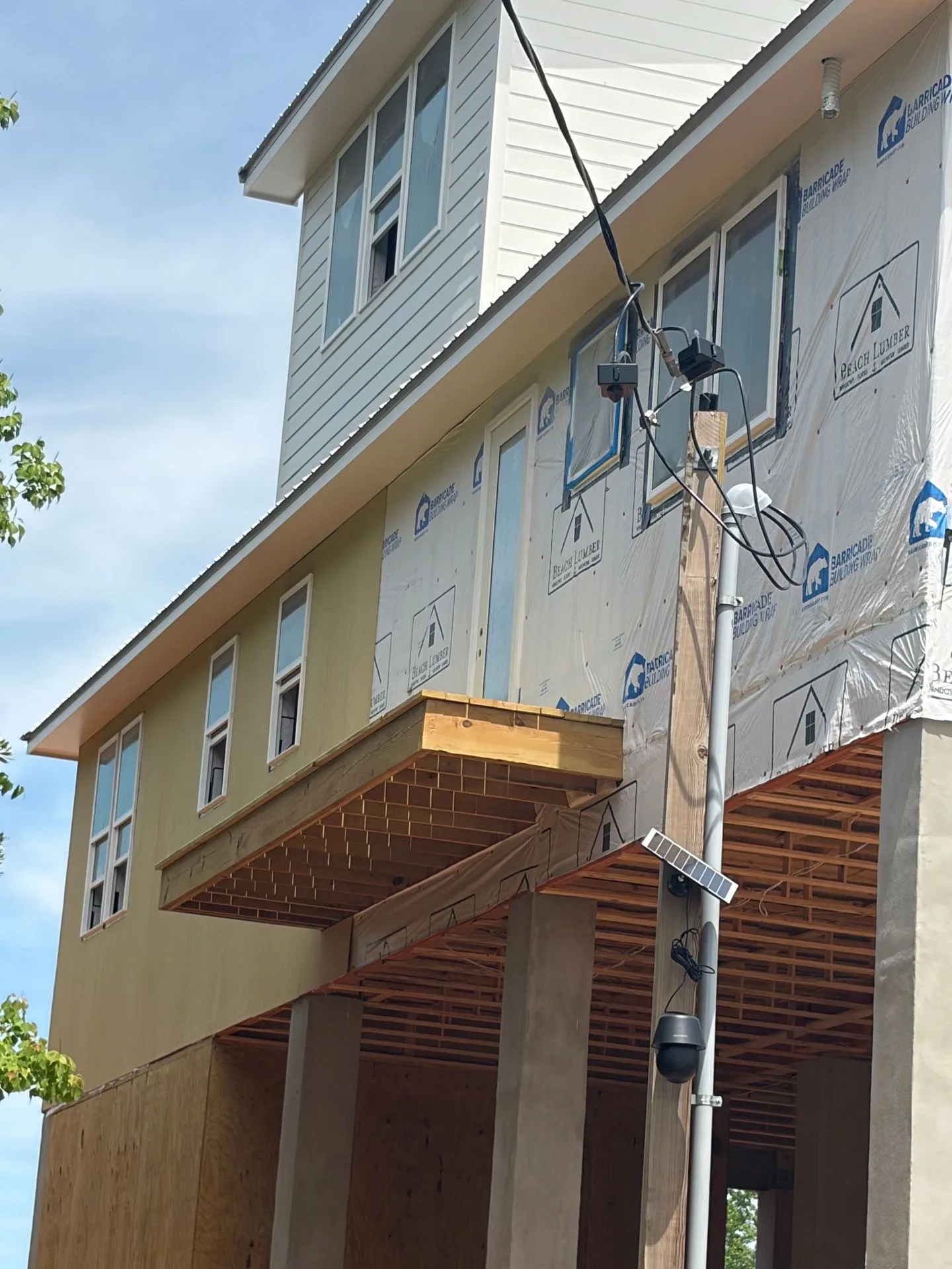 Near-complete elevated custom home with metal roof by 3H Construction