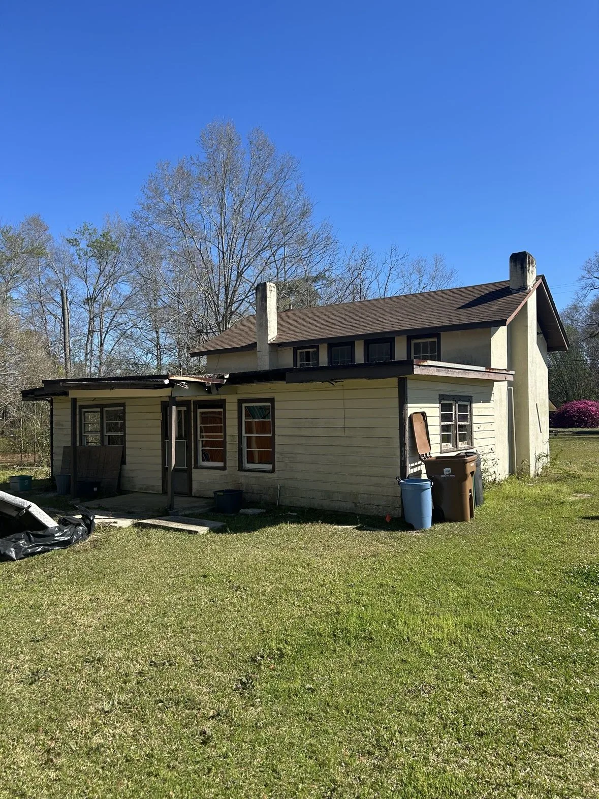 Older cottage-style home with two chimneys before a home addition project by 3H Construction