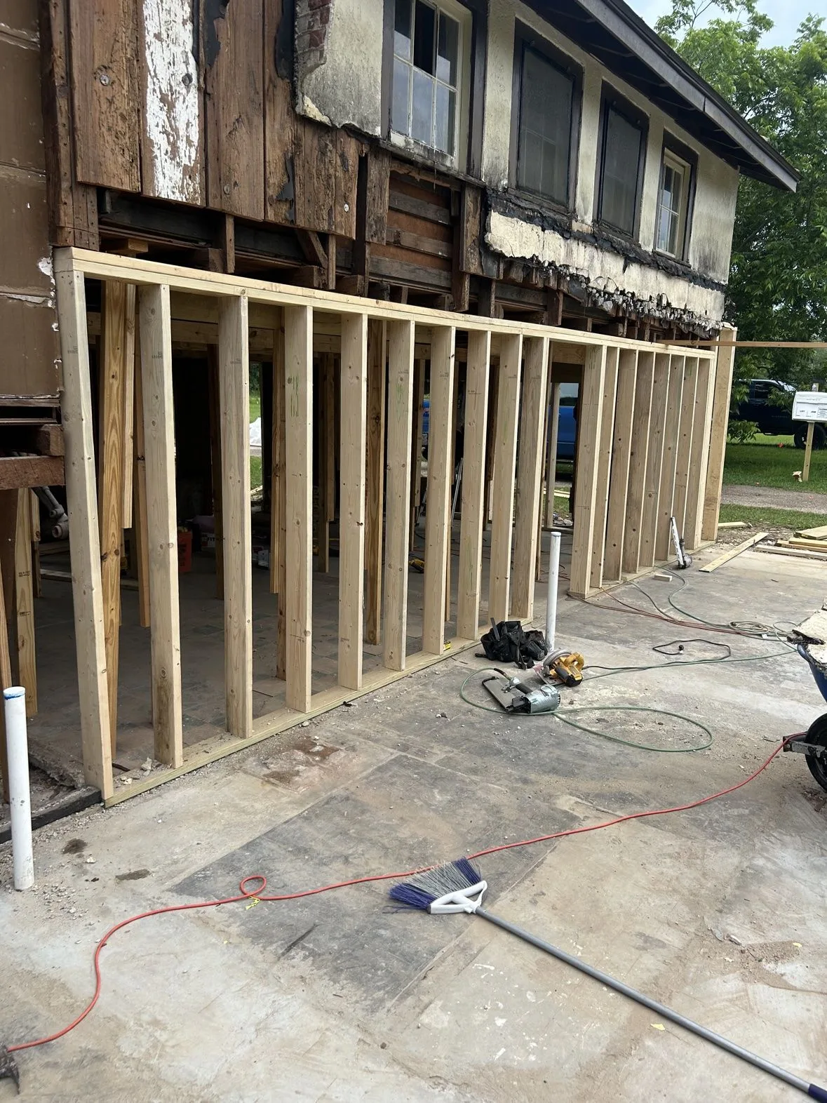 Wood wall framing going up for a home addition beside the original house
