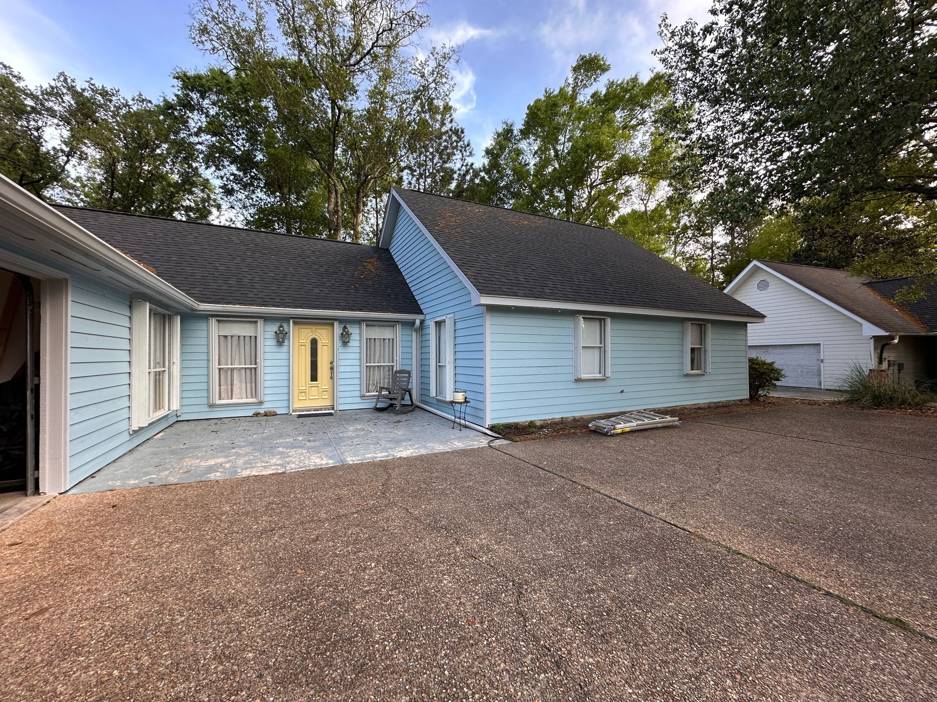 Ranch house exterior after full repaint, sky-blue siding with yellow front door