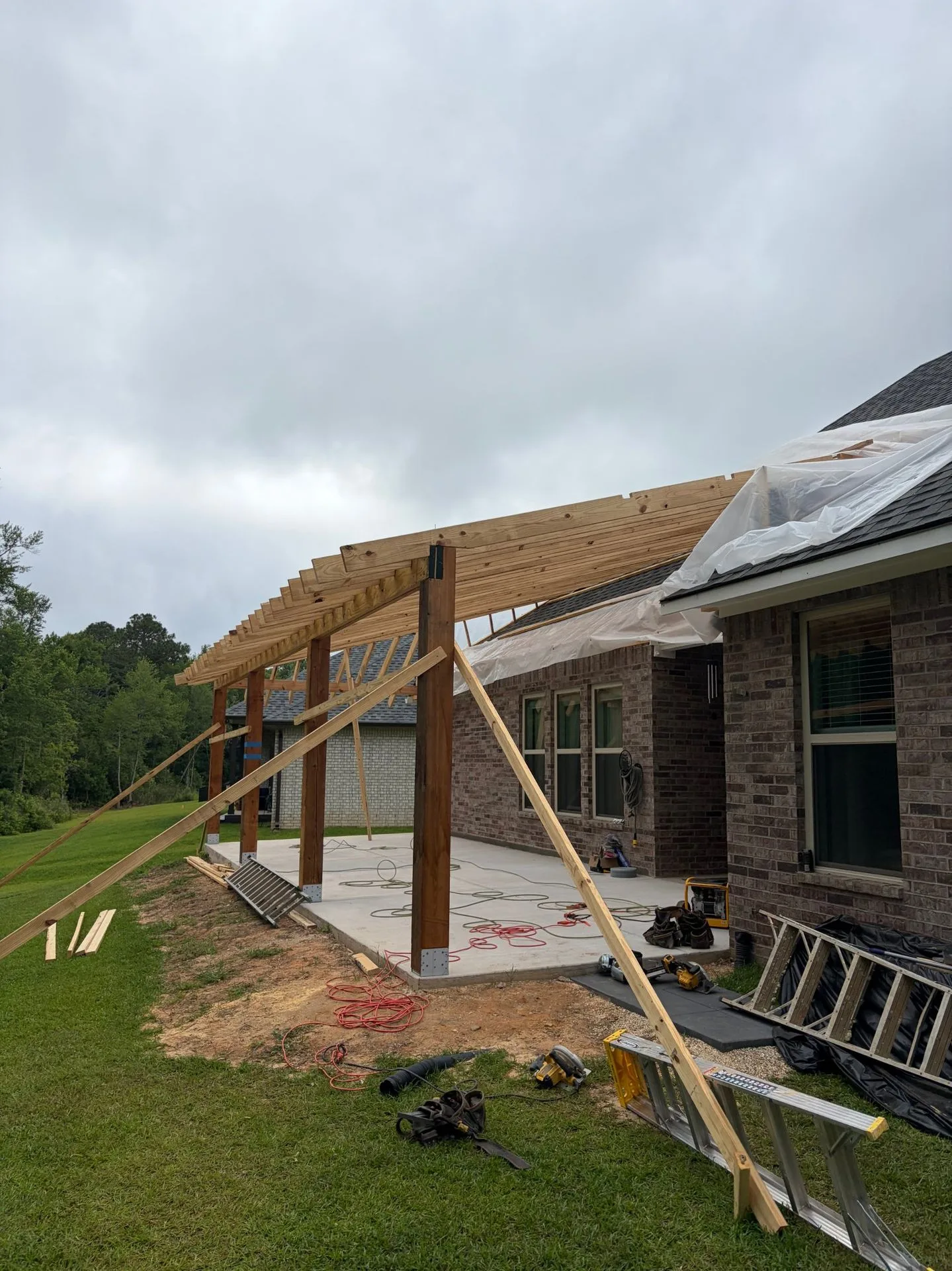 Porch roof rafters being framed into the house roof by 3H Construction