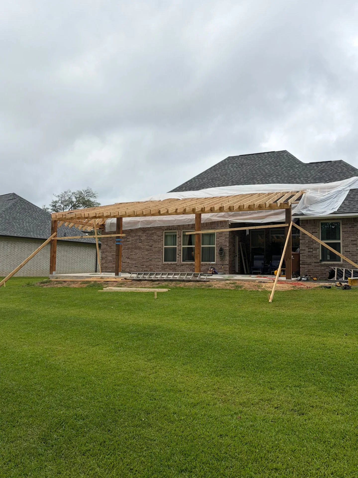 Porch roof rafter framing viewed from the yard by 3H Construction