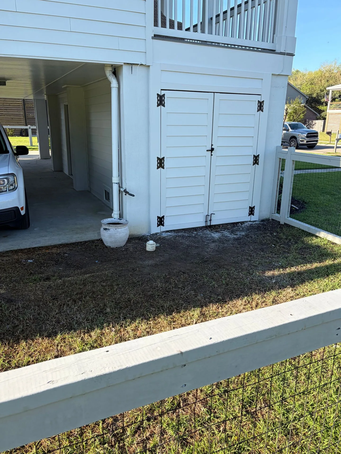 White louvered double doors enclosing under-house storage on an elevated home by 3H Construction