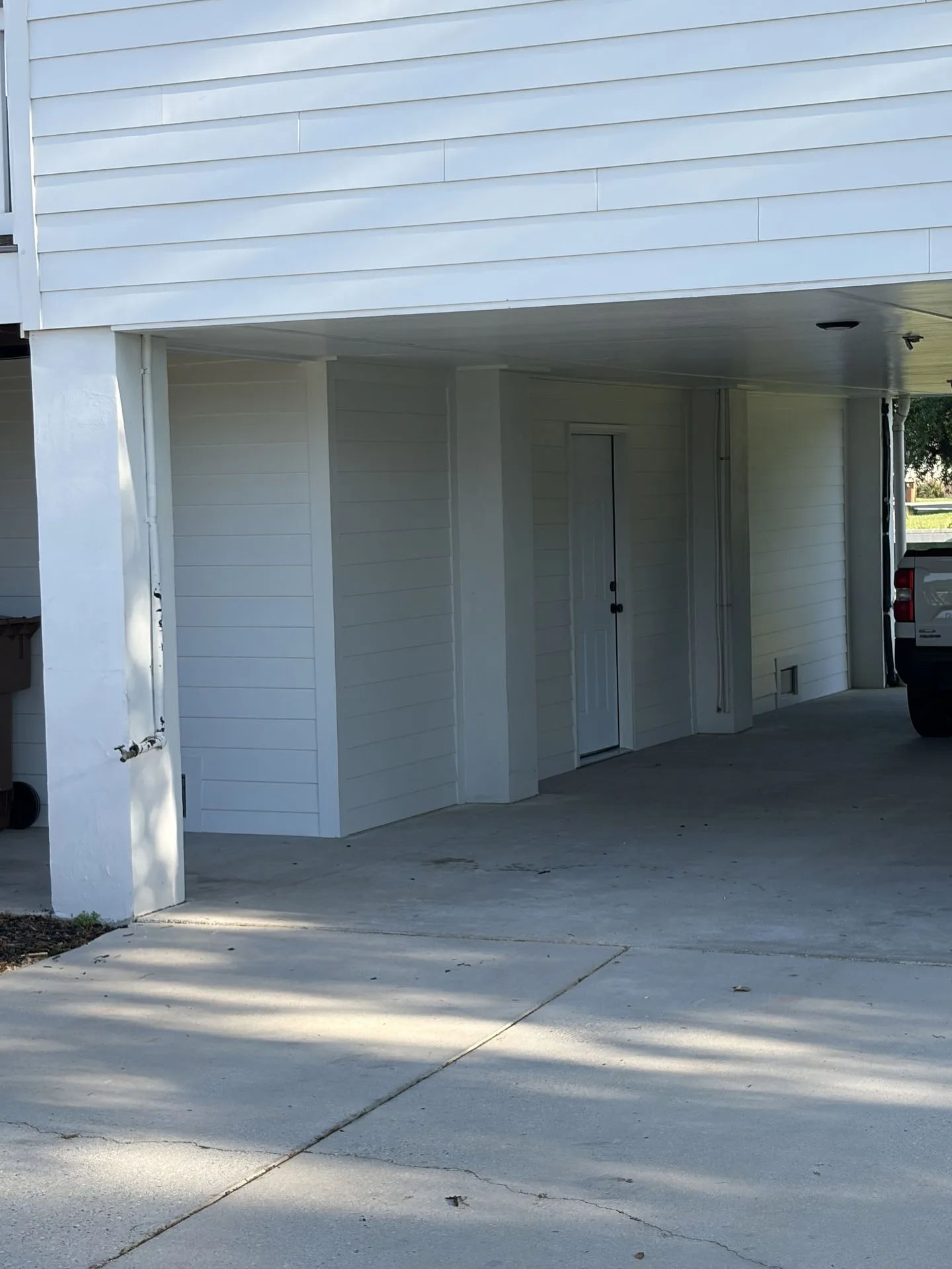 Finished white siding enclosure under an elevated home by 3H Construction