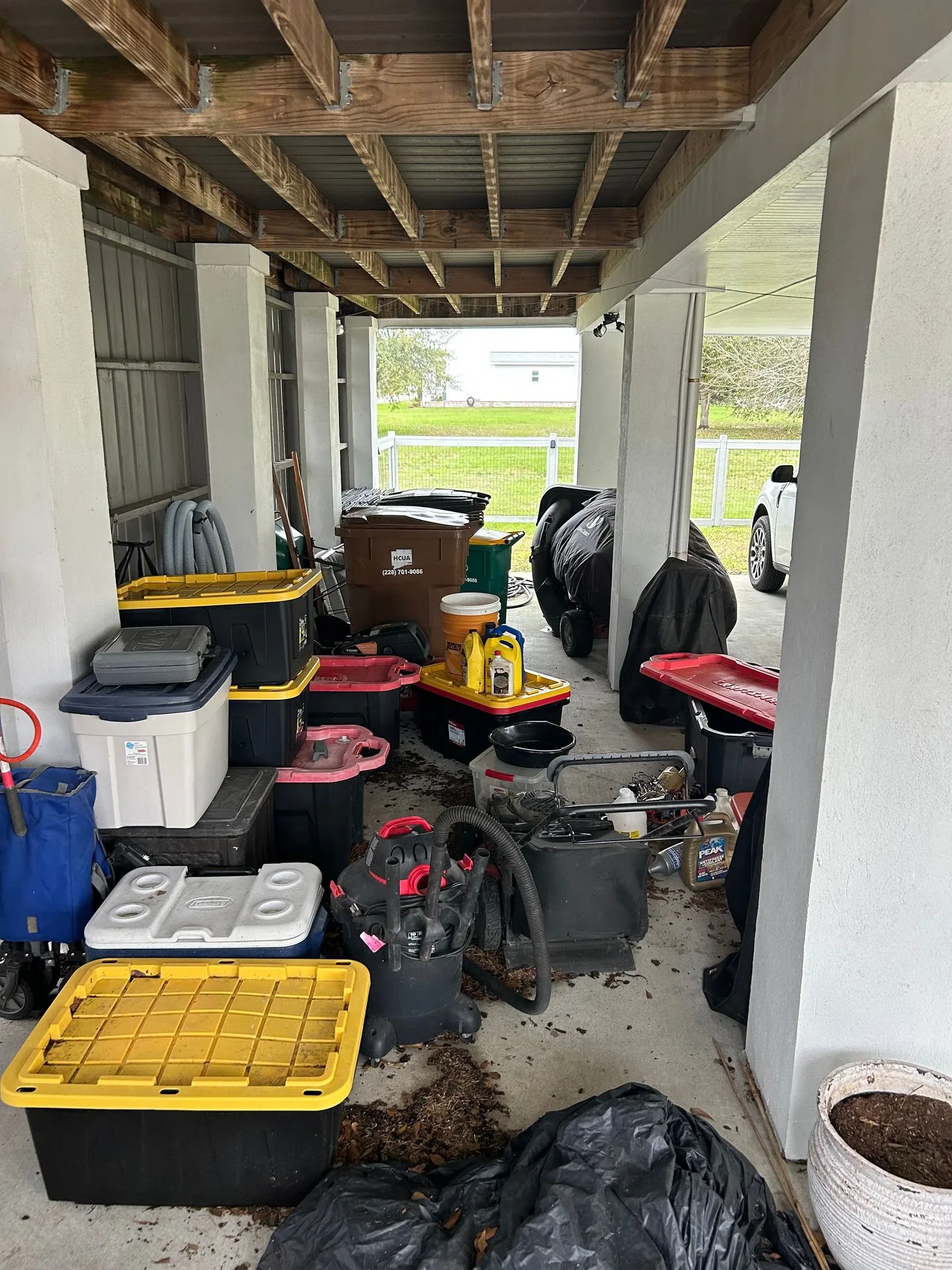 Cluttered under-house storage area beneath an elevated home before 3H Construction's enclosure work